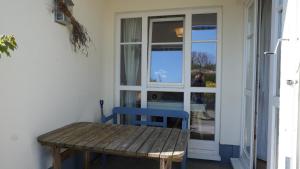einem Holztisch und einem blauen Stuhl vor einer Tür in der Unterkunft Wiecker Apartment am Ryck in Greifswald