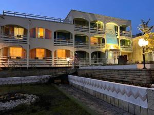 a large white building with its lights on at Хотел Диамант Hotel Diamond in Balchik