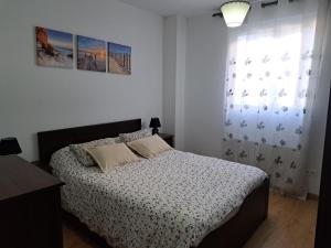 um quarto branco com uma cama e uma janela em Apartamento en Badames em Bádames
