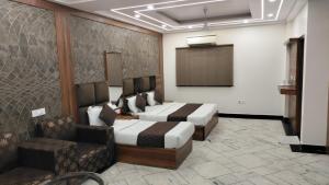 ニューデリーにあるHOTEL SINGH CONTINETALのベッド2台とソファが備わるホテルルームです。