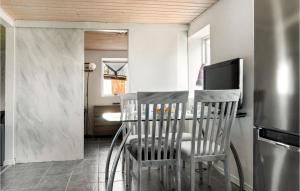 een keuken met een tafel met stoelen en een koelkast bij 2 Bedroom Nice Home In Bedsted Thy in Bedsted Thy