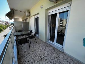 uma varanda com uma mesa e cadeiras num edifício em Amalia Apartment em Perea