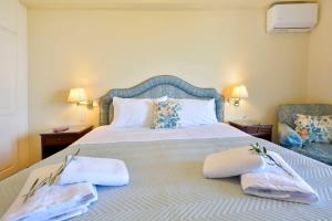 a bedroom with a large bed with towels on it at Corfu Ionian Blue in Anemómylos