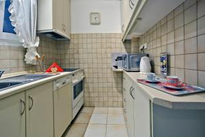 a small kitchen with a sink and a microwave at Corfu Ionian Blue in Anemómylos