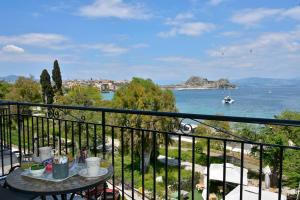 d'un balcon avec une table et une vue sur l'eau. dans l'établissement Corfu Ionian Blue, à Anemómylos