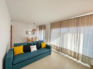 a blue couch in a living room with a window at Domuum Holidays - PARADISE VILLAGE in Salou