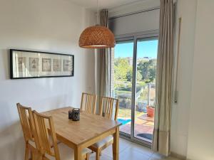 a dining room with a table and chairs and a window at Domuum Holidays - PARADISE VILLAGE in Salou