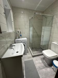 uma casa de banho com um lavatório, um chuveiro e um WC. em Amalia Apartment em Perea