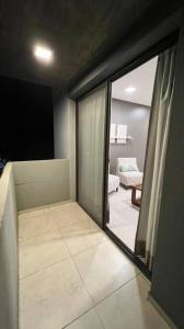 Zimmer mit Glasschiebetür zum Wohnzimmer in der Unterkunft Pellegrini Home in Godoy Cruz