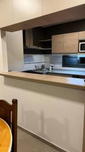 eine Küche mit einer Spüle, einer Mikrowelle und einem Tisch in der Unterkunft Pellegrini Home in Godoy Cruz