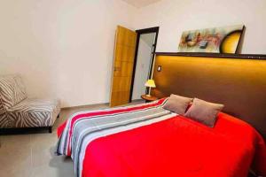 ein Schlafzimmer mit einem roten Bett und einem Sofa in der Unterkunft Pellegrini Home in Godoy Cruz