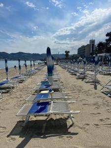 una fila di sedie a sdraio e ombrelloni in spiaggia di Casa di Riccardo a Savona