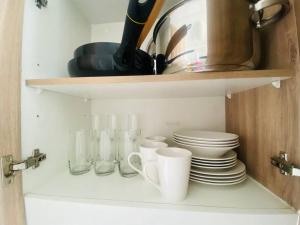 a kitchen shelf with plates and cups on it at Confortable Apartamento para 3 in Santiago