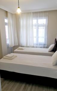 duas camas num quarto com duas janelas em Sweet flat istanbul em Istambul