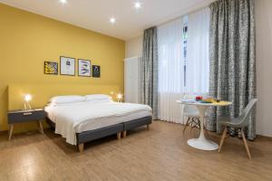 a bedroom with a bed and a table and a table at Aqualago casa vacanze apartment A in Verbania