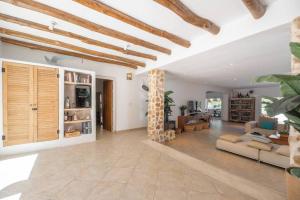 uma sala de estar com paredes brancas e tectos em madeira em Villa en San José con vistas al mar, piscina y 7 habitaciones em Cala Vadella