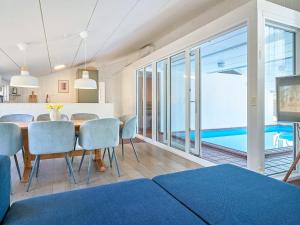 a dining room with a table and chairs and a pool at 8 person holiday home in Nex in Neksø