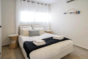 a bedroom with a large white bed with towels on it at YalaRent Cliff side villa with private pool in Eilat +29 photos