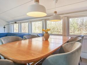ein Esszimmer mit einem Holztisch und Stühlen in der Unterkunft 8 person holiday home in Nex in Neksø