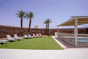 un patio con sillas, una piscina y una valla en YalaRent Cliff side villa with private pool, en Eilat