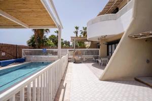 a balcony with a swimming pool and a house at YalaRent Cliff side villa with private pool in Eilat