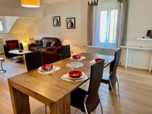 a living room with a wooden table and chairs at L'Ourson in Gérardmer