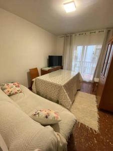 um quarto com duas camas e uma mesa e uma janela em El Antequerano em Antequera