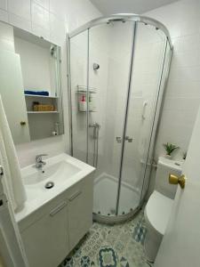 uma casa de banho com um chuveiro, um lavatório e um WC. em El Antequerano em Antequera