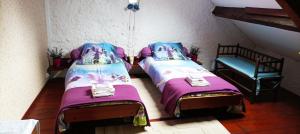 1 dormitorio con 2 camas y 1 silla en La Mez a Nine chambres d'hôtes, en Buxières-sous-Montaigut