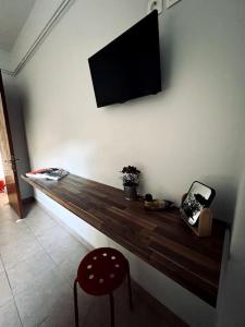 un banco de madera con TV en la pared en Olympus and Sea View Apartment en Platamonas