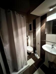 a bathroom with a toilet and a shower curtain at Olympus and Sea View Apartment in Platamonas