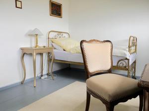 a bedroom with a bed and a chair and a table at Vierseitenhof Hasenfelde - Ferienwohnung Feldblick in Steinhöfel