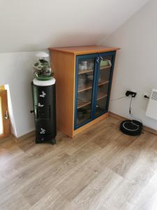 a room with a cabinet and a wooden floor at Glamping APARTMA NA KOZOLCU 