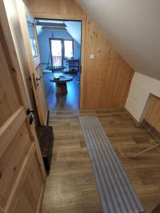 een zolderkamer met een deur en een houten vloer bij Glamping APARTMA NA KOZOLCU 