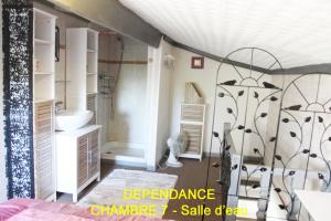 a bathroom with a bed and a sink and a shower at Chez Martine et Bernard in Saint-Vincent-Sterlanges