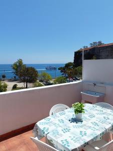 una mesa y sillas en un balcón con vistas al océano en A Casicedda, en Lipari