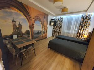 sypialnia z łóżkiem, stołem i obrazem w obiekcie Komfortowo i cicho - Apartament w Krakowie