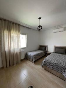 een slaapkamer met 2 bedden en een raam bij 2 Bedrooms apartment swimming pool in Monastir