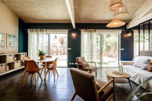 un soggiorno con un divano, un tavolo e delle sedie di Villa Eden Bleu - Piscine et jacuzzi privé - Logement classé 4 étoiles a Biscarrosse