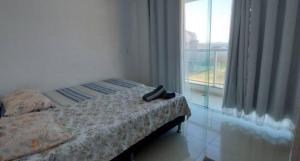 a bedroom with a bed and a large window at Apartamento de 3 quartos com vista para o mar in Arraial do Cabo +17 photos