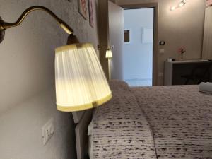 um quarto com uma cama com um candeeiro em B&B villa orchidea em Ricadi