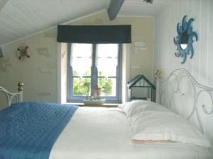 sypialnia z białym łóżkiem i oknem w obiekcie Chez Martine et Bernard w mieście Saint-Vincent-Sterlanges