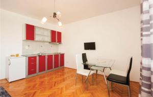 a kitchen with red cabinets and a glass table at Cozy Apartment In Sibenik With House Sea View in Krapanj