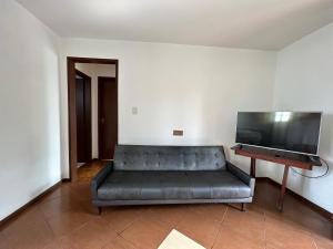 uma sala de estar com um sofá e uma televisão de ecrã plano em Apto familiar em Cachoeirinha-RS em Cachoeirinha