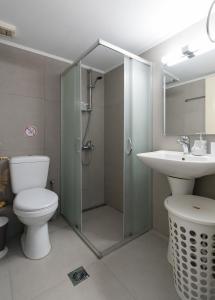 a bathroom with a shower and a toilet and a sink at The City Apartment in Lixouri