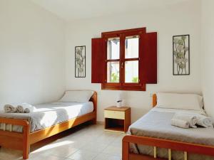 1 dormitorio con 2 camas y ventana en Casa Mara, en Cala Liberotto