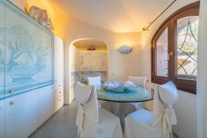 a dining room with a table and white chairs at Villa Ilda in Cannigione