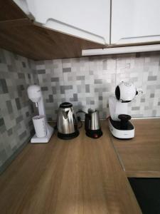 a kitchen counter with appliances on a wooden counter top at Tea Apartment in Kumanovo