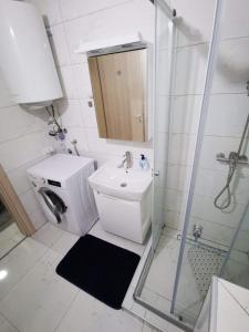 a bathroom with a toilet and a sink and a shower at Tea Apartment in Kumanovo