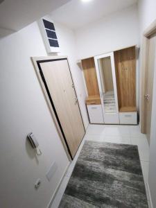 a bathroom with a door and a mirror and a rug at Tea Apartment in Kumanovo